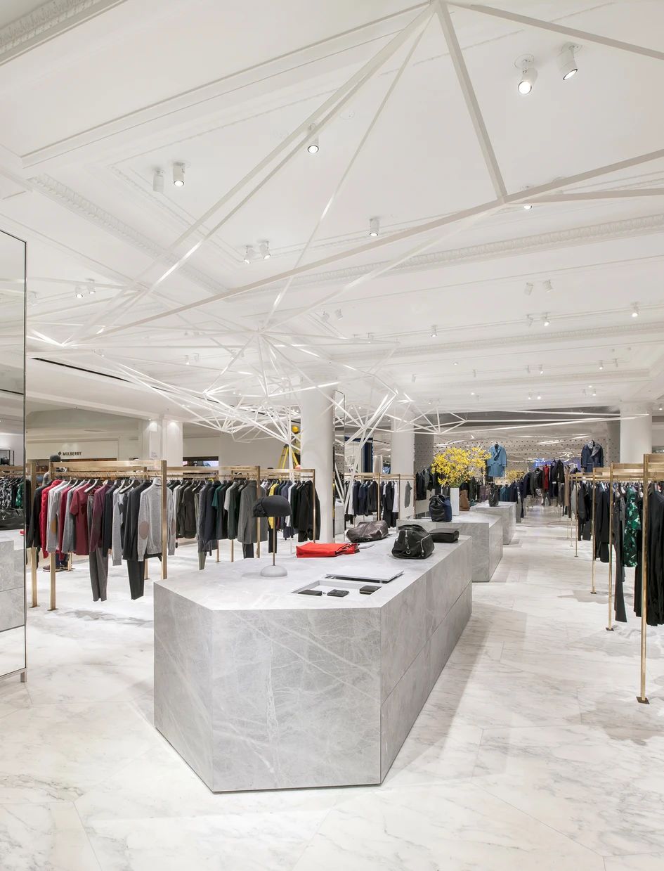 Selfridges menswear designer floor, sculptural white ceiling, brass rails and marble plinths
